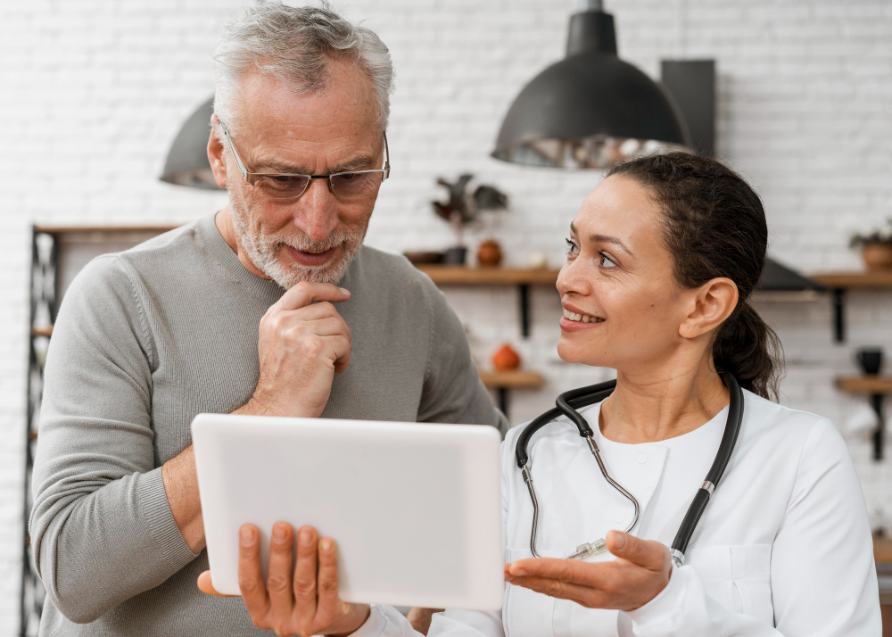 Doctor explaining treatment options to a patient using a tablet, improving patient experience through communication.