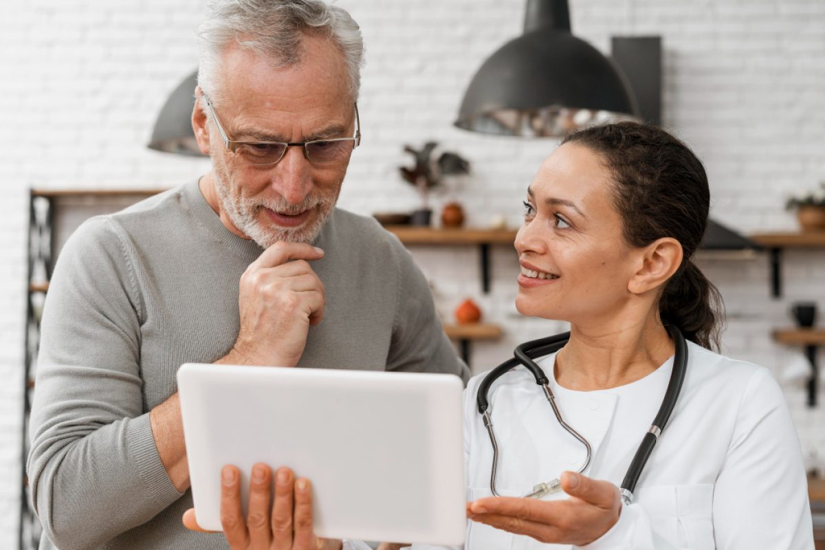 Doctor explaining treatment options to a patient using a tablet, improving patient experience through communication.