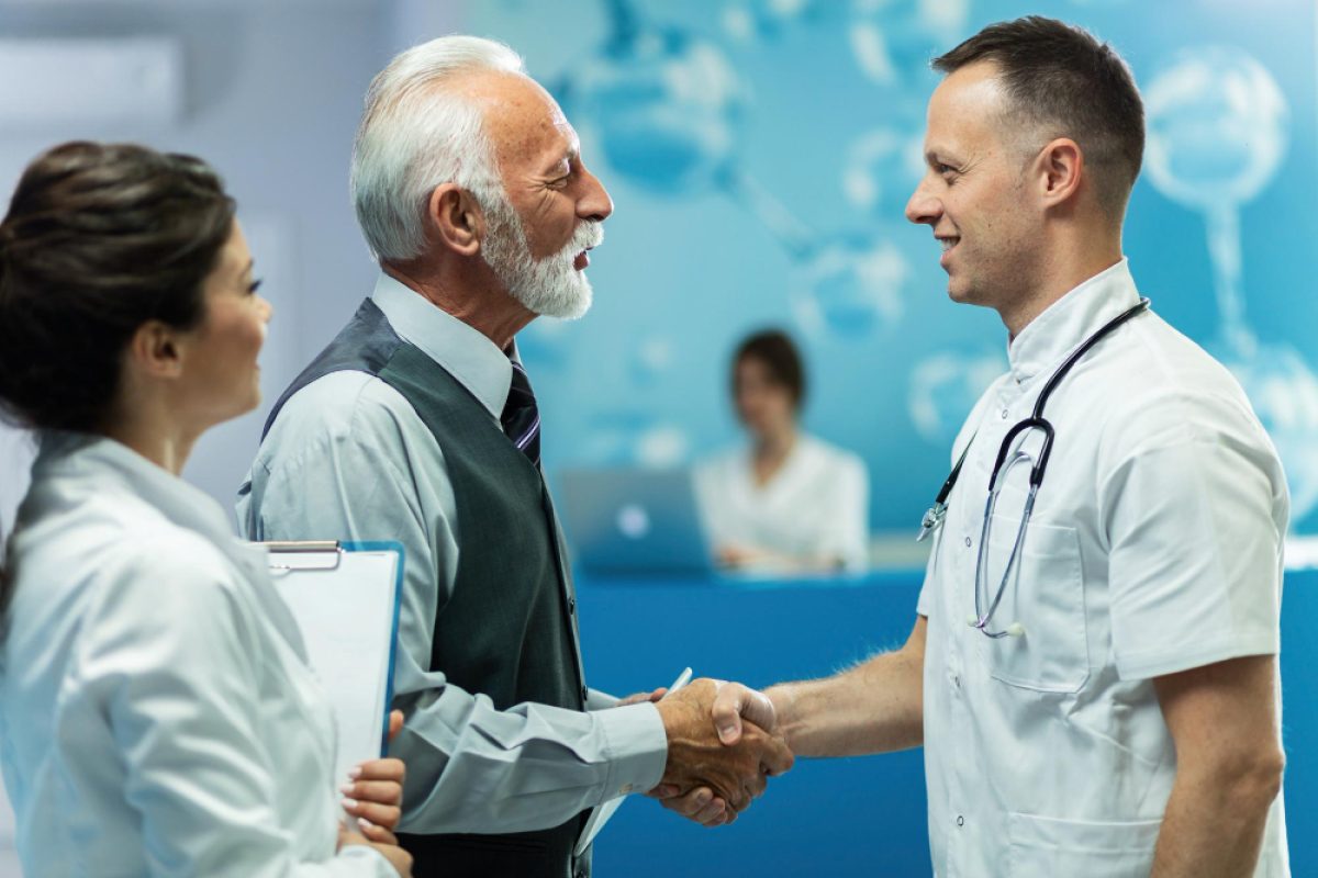 Senior patient shaking hands with a doctor, representing patient satisfaction in healthcare.